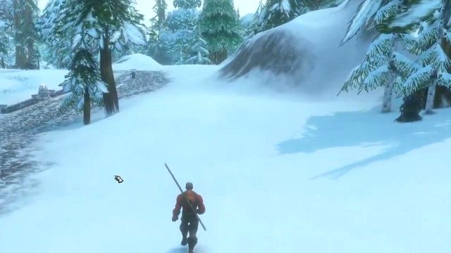 A Human Warlock walking down a snowy road in Dun Morogh, between pine trees